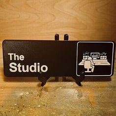 the studio sign is displayed on a wooden table