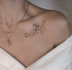 a woman wearing a white dress with tattoos on her chest