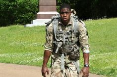 a man in camouflage walking down a path