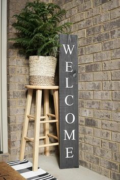 a welcome sign next to a potted plant