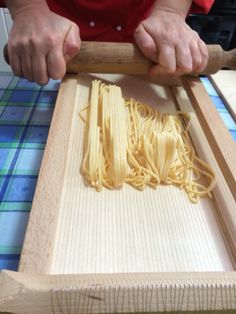 a person is making pasta on a wooden board