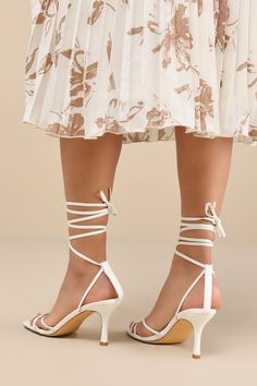 Make an entrance unlike any other with a fabulous look like the Lulus Lawrance White Lace-Up High Heel Sandals! Smooth faux leather shapes these trendy lil' heels that feature a classic square-toe footbed, a network of slender straps that create a peep-toe upper, and matching straps that weave through a supportive heel strap to wrap and tie above the ankle. 3. 25" wrapped stiletto heel. Cushioned insole. Rubber sole has nonskid markings. Man made materials. Imported. Lulus | Lawrance White Lace-Up High Heel Sandal Heels | Size 10. Chic Fitted Sandals With Block Heel, White Square Toe Heels With 4-inch Heel, Fitted Summer Wedding Shoes With Heel Strap, Summer Event Heels With Sculpted Heel, Chic Spring Wedding Shoes With Padded Heel, Elegant Low Heel Wedding Shoes For Summer, Square Toe Sandals For Summer Wedding, Elegant Summer Heels With Heel Strap, Fitted Square Toe Heels For Wedding