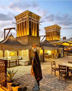 a woman standing in front of an outdoor dining area