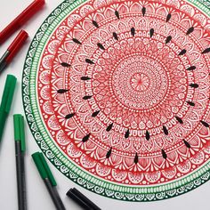 a red and green drawing with markers on the table next to some crayons