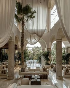 an elegant lobby with white drapes and couches