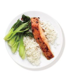 a white plate topped with rice and meat next to broccoli on top of it