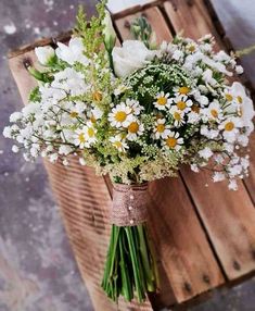 A bouquet of wild daisies and baby's breath and other small white flowers wrapped with a burlap strip on deep stems with three small white beaded pins. Simple and rustic Baby's Breath Bridal Bouquet, Simple Wedding Bouquets, Wildflower Wedding Bouquet, Spring Wedding Bouquets, Simple Wedding Flowers, Daisy Wedding, Daisy Bouquet, Boquette Flowers, Spring Wedding Flowers