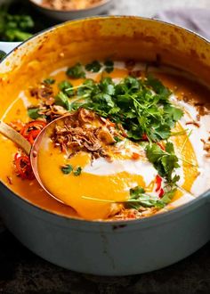 a pot filled with soup and garnished with parsley