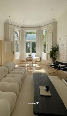 a living room filled with lots of furniture next to a large window on the wall