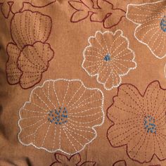 a close up of a pillow with flowers on it