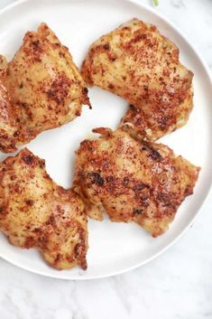 four pieces of chicken on a white plate