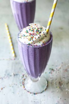 two glasses filled with ice cream and sprinkles on top of a table