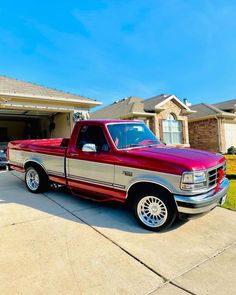 a red pick up truck parked in front of a house