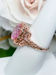 Pink Cubic Zirconia Ring Speechless Design#103 Custom Made Inspired by Victorian era filigree designs, I now offer this stunning Antique inspired ring in rose gold plated sterling silver. This fabulous ring is set with a 6ct flawless Pink Cubic Zirconia gemstone. The round full cut high-quality pink gemstone is 12mm (just shy of 1/2th of an inch) in diameter. The inside of the band is marked 925 for sterling. Notice the beautiful intricate bow and floral-like design of the silver filigree settin Elegant Pink Gold Jewelry With Center Stone, Classic Rose Gold Jewelry With Accent Stones, Rose Gold Morganite Rings With Diamond Cut, Rose Gold Fine Jewelry With Intricate Design For Wedding, Rose Gold Filigree Jewelry For Wedding, Rose Gold Filigree Wedding Jewelry, Exquisite Rose Gold Jewelry With Center Stone, Pink Rings With Intricate Design For Anniversary, Rose Gold Rings With Intricate Design