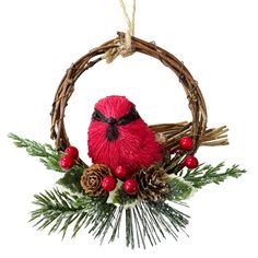 a red bird sitting on top of a christmas wreath