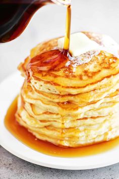 a stack of pancakes with syrup being drizzled on top