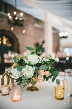 flowers and candles on a white table cloth