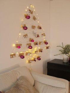 a living room with a christmas tree made out of boxes and lights on the wall