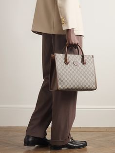 Gucci's tote bag combines the hallmarks of the 'Ophidia' collection from 2018 with the iconic 'GG Supreme' monogram from the 1930s. Made in Italy from durable coated-canvas and brown leather, it's built to hold its structured shape, fully lined in canvas and has the option of a shoulder strap or top handles. High-end Monogram Canvas Bag For Formal Occasions, Formal Monogram Canvas Bag With Dust Bag, High-end Formal Monogram Canvas Bag, Gucci Double Handle Satchel For Shopping, Formal Monogram Canvas Bag With Top Handle, Gucci Rectangular Satchel For Shopping, Formal Monogram Canvas Tote Bag, Gucci Tote Satchel For Shopping, Gucci Top Handle Shoulder Bag With Dust Bag