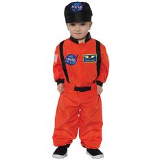 a little boy dressed in an orange astronaut suit and black hat, standing with his hands on his hips