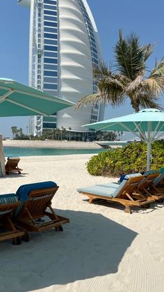 lounge chairs and umbrellas on the beach in front of burj al arab hotel