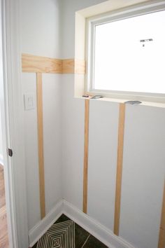 the corner of a room that is being painted white and has wood trim on it