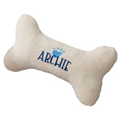 a bone shaped pillow with the word'archite'printed on it and a paw print