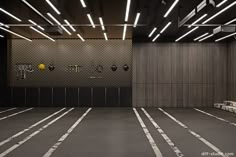 an empty parking garage with lights on the ceiling and benches in front of the wall