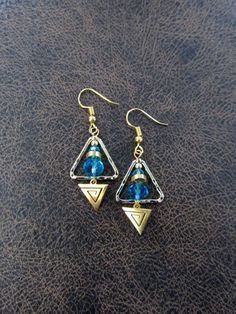 Hammered brass and crystal with French hooks Gold Triangle Metal Jewelry, Blue Triangle Earrings For Gift, Nickel Free Triangle Metal Earrings, Nickel-free Metal Triangle Earrings, Blue Bohemian Triangle Earrings, Bohemian Blue Triangle Earrings, Blue Metal Crystal Earrings With Ear Wire, Blue Crystal Earrings With Metal Ear Wire, Blue Bohemian Crystal Earrings