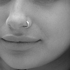 a close up of a person with a nose ring on their nose and piercing in the middle