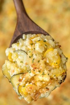 a wooden spoon filled with food on top of a table