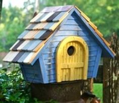 a bird house sitting on top of a tree stump