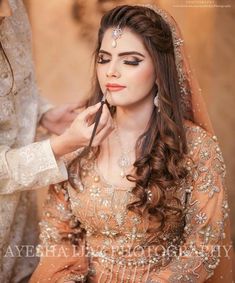 a bride getting ready for her wedding day with makeup by ayeesh kal photography