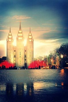 the salt lake temple lit up at night with red lights on it's sides