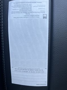 a close up of a piece of paper on the back of a car seat belt