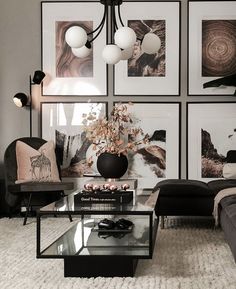 a black and white living room with pictures on the wall, couches and coffee table