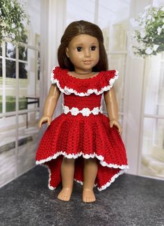 the doll is wearing a red dress with white trim