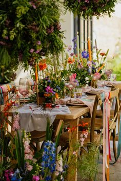 the table is set with flowers and candles for an outdoor dinner or brunch