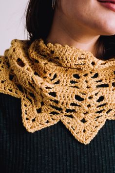 a woman wearing a yellow crochet scarf