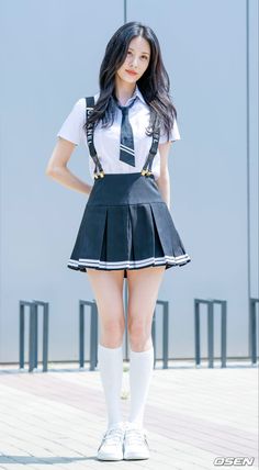 a girl in a school uniform posing for the camera