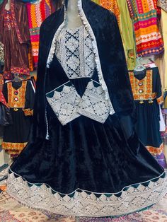 This stunning Afghani velvet frock is made of the finest silk velvet, and is embroidered with intricate white charmadozi designs. The charmadozi embroidery is a traditional Afghan technique that uses charma to create intricate patterns and designs. The frock is fully lined and has a fitted bodice with long sleeves. It falls to the ankles in a graceful A-line skirt. The frock is perfect for a special occasion, such as a wedding or a formal event. It is also a great choice for everyday wear, as it Festive Velvet Anarkali Dress, Traditional Festive Winter Dresses, Traditional Winter Festive Dresses, Festive Velvet Embroidered Dress, Festive Embroidered Velvet Dress, Traditional Velvet Dresses With Dabka Work, Festive Velvet Dress With Dabka Work, Fitted Velvet Embroidered Dress, Fitted Embroidered Velvet Dress