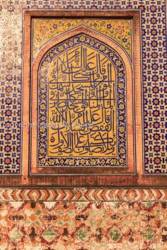 an intricately decorated wall with arabic writing on it