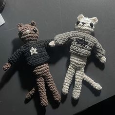 two crocheted teddy bears sitting next to each other on top of a table