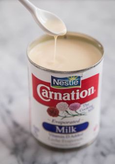 a can of milk with a spoon sticking out of it