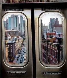 the view from inside an airplane window looking down at buildings and cars on the street