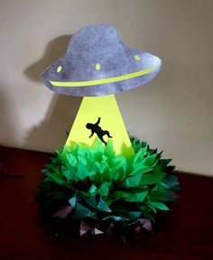 a paper model of an alien dog on top of a green plant