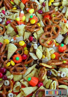 a pile of halloween snack mix with candy corn and pretzels in the middle