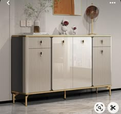 a sideboard with two doors and three drawers on the bottom, in front of a white wall