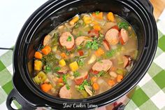 slow cooker bean soup with sausage and kale in a crock pot on the table