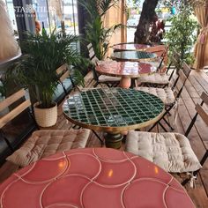 several tables and chairs are lined up on the wooden flooring in an outdoor cafe